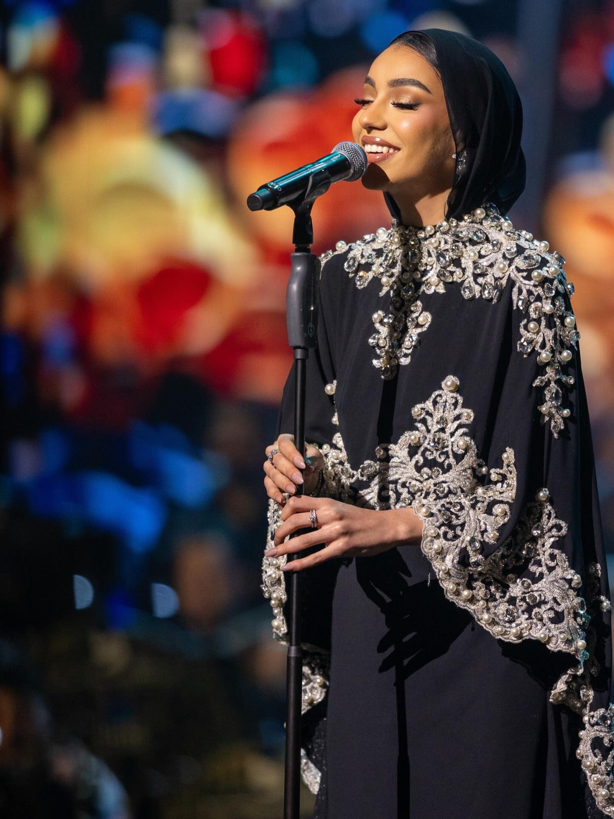 Dodona Moments: black cape gown with silver embroidery, on stage